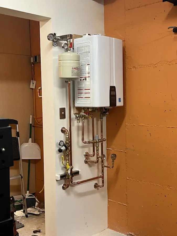 Plumbing technician inspecting water heater connections in South Annville